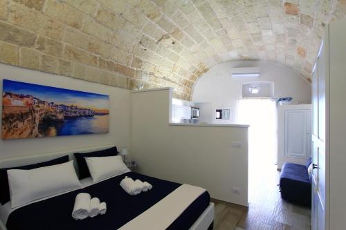 滨海波利尼亚诺Il Viandante的一间卧室设有一张床和石墙