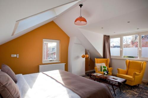 奥特马瑟姆B&B Ootmarsum的一间卧室配有一张床和两张黄色椅子