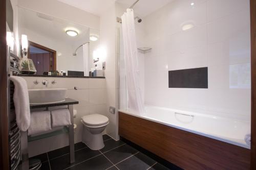 威姆斯洛斯坦尼兰斯酒店的带浴缸、盥洗盆和卫生间的浴室