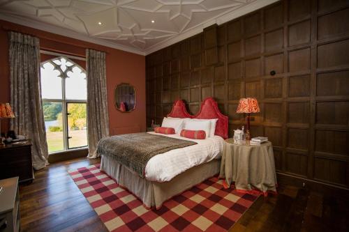惠特彻奇The North Wing - Combermere Abbey的一间卧室配有一张带红色枕头的大床