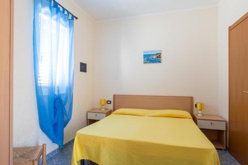 维耶斯泰卡尔马度假屋的一间卧室设有黄色的床和窗户。