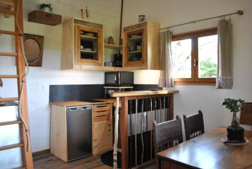 Chaussan艾图纳尔贝沏山林小屋的厨房配有木制橱柜、桌子和冰箱。