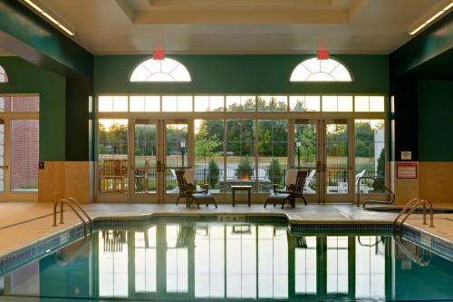 萨拉托加泉萨拉托加赌场酒店的一个带椅子和桌子的游泳池以及窗户