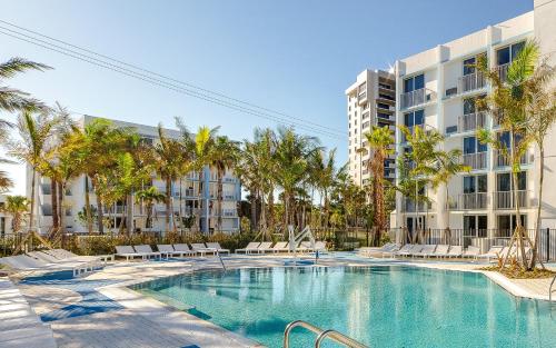 劳德代尔堡Plunge Beach Resort的棕榈树建筑前的游泳池