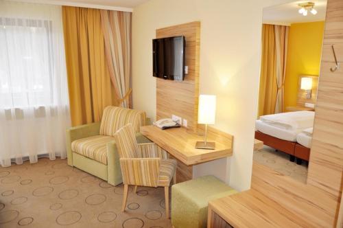 KleinlobmingGasthof Landhotel Hubmann的酒店客房配有书桌和床。