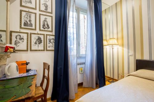 罗马梵蒂冈艾琳客房旅馆的一间卧室配有一张带蓝色窗帘的床和一扇窗户