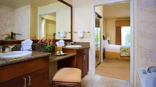 拉斯维加斯塔希提村水疗度假酒店的一间带两个盥洗盆的浴室和一间带一张床的浴室