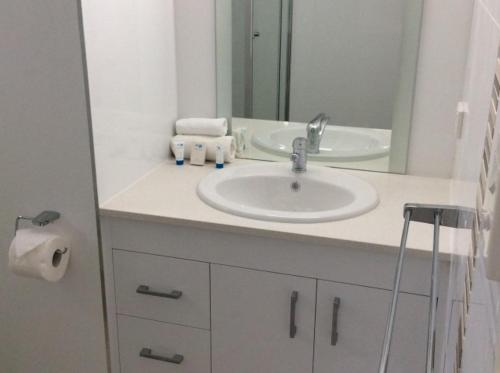 米申海滩奇拉玛4号公寓的浴室设有白色水槽和镜子