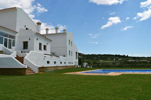 El AlmiceránHotel Rural Ibipozo的一座白色的房子,前面设有一个游泳池