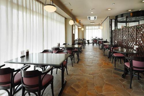 东村山市久米川翼酒店的餐厅里一排桌椅