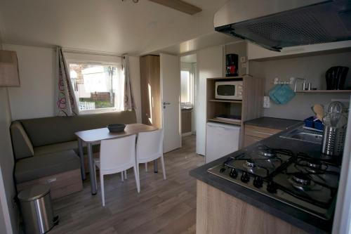布尔沙伊德Camping Panorama的小厨房以及带桌子和沙发的客厅。