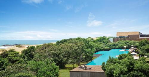 雅拉亚拉杰特威酒店的享有游泳池的顶部景色,背景是大海