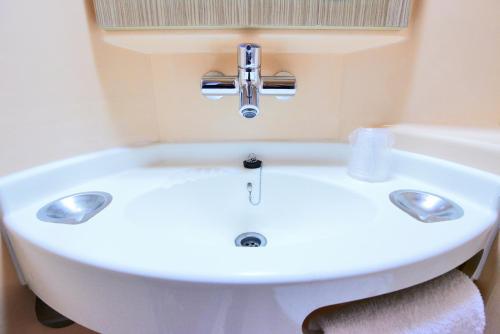 孔夫朗-圣奥诺里讷夫朗 - 圣 - 霍诺普瑞米尔经典酒店的带浴缸的浴室内的白色水槽