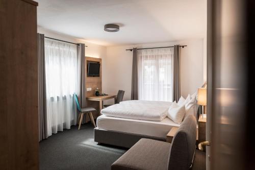 圣马蒂诺Garni Grünau的配有一张床和一张书桌的酒店客房