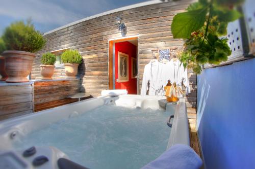 萨马坦欧卡纳德美食家之家酒店的浴室设有盆栽植物浴缸