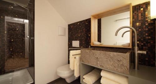 因斯布鲁克木屋旅馆的一间带水槽、卫生间和淋浴的浴室