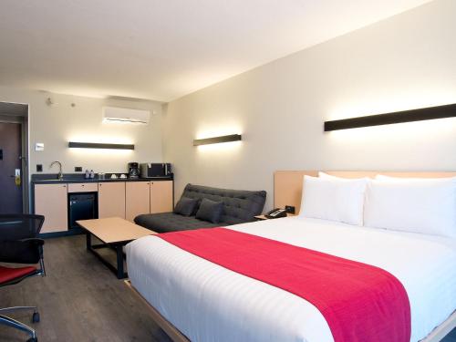 圣地亚哥圣地亚哥机场城市快捷酒店的酒店客房设有一张大床和一张沙发。
