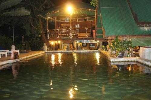 皮皮岛热带花园简易别墅度假村的一座游泳池,位于一座建筑的后面