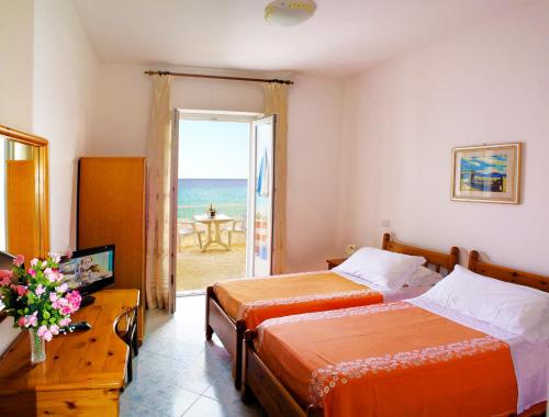 伊斯基亚拉贡德拉酒店的一间带两张床的卧室,享有海景
