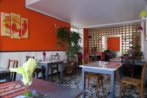巴涅尔德比戈尔贝亚恩酒店的一间带桌椅和橙色墙壁的餐厅