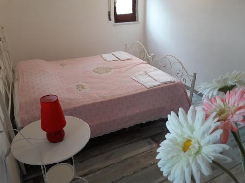 莫诺波利Villa Capitolo的一间小卧室,配有一张带桌子和鲜花的床