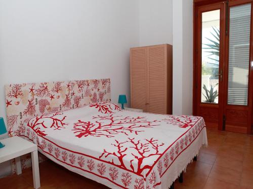 托雷苏达Villa Giordano的一间卧室配有一张带红白毯子的床
