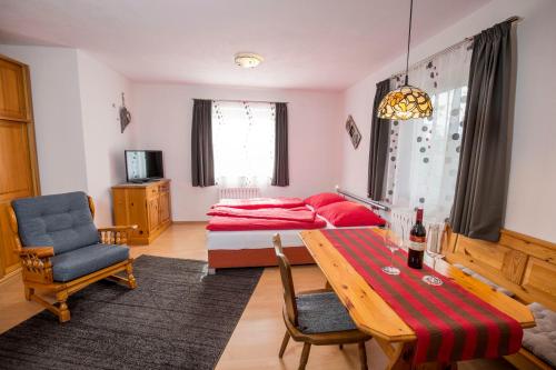 洛伊塔施Haus Hahnenhof的一间带床和桌子的客厅以及一间卧室