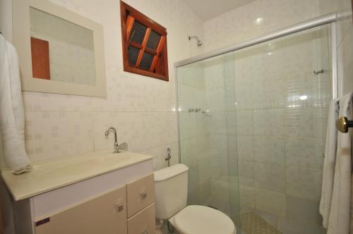 布希奥斯Pousada New Paradise的一间带卫生间和玻璃淋浴间的浴室