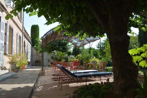 格拉斯莱斯派西弗洛尔斯住宿加早餐旅馆的庭院设有长凳、桌子和树