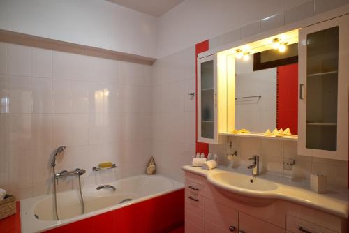 锡蒂亚Sitia Blue的带浴缸、水槽和镜子的浴室