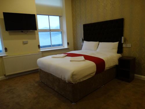 布特尔特里维利斯塞福思酒店的一间卧室配有一张大床和两条毛巾