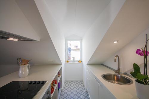 杜布罗夫尼克幽雅公寓的厨房配有白色的柜台、水槽和窗户。