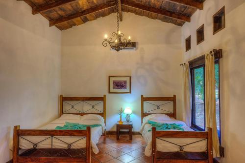 Cañas拉帕西菲卡庄园酒店的一间卧室配有两张床和吊灯。