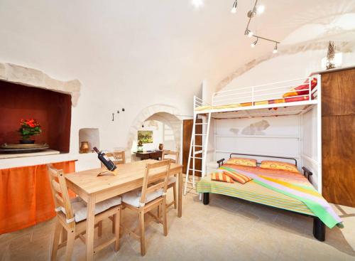 奥斯图尼Ostunica的一间卧室配有一张双层床和一张木桌及椅子。