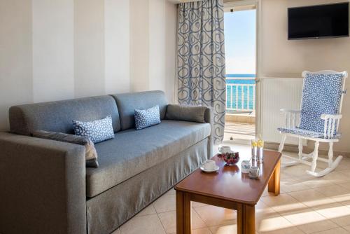尼亚·卡利克拉提亚Georgalas Sun Beach Resort的客厅配有沙发和桌子