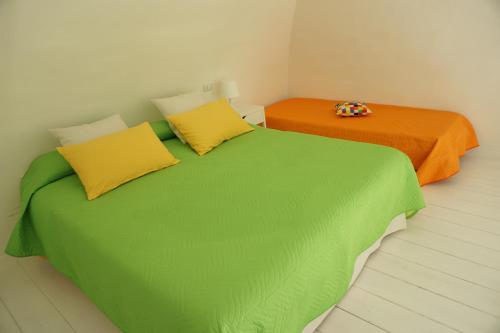 巴里Dante Home - Bari Centro的两张带绿色和橙色床单的床
