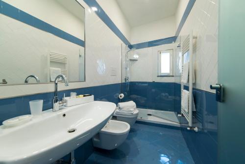 维耶特里B&B Umberto的蓝色和白色的浴室设有水槽和卫生间