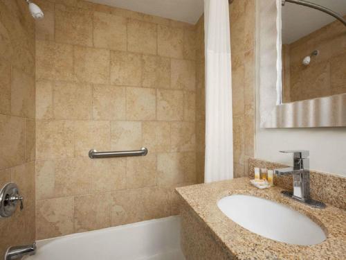 西雅茅斯Days Inn by Wyndham - Cape Cod的一间带水槽、浴缸和镜子的浴室
