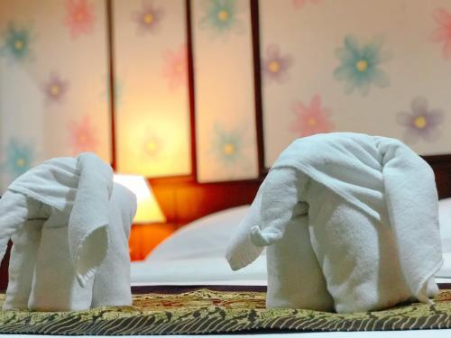 莱卡邦兰花度假酒店的坐在桌子上的两只白色玩具大象