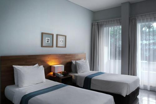 丹戎潘丹比利顿酒店的酒店客房设有两张床和窗户。