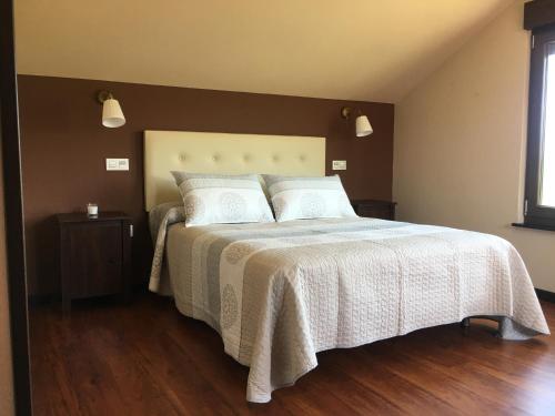 OturChalet La Caleya的一间卧室配有一张带白色床罩的床