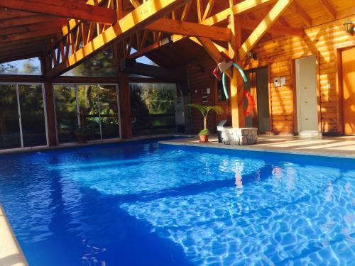 拉安戈斯图拉镇恩卡特德尔里约酒店的一座带木制天花板的别墅内的游泳池