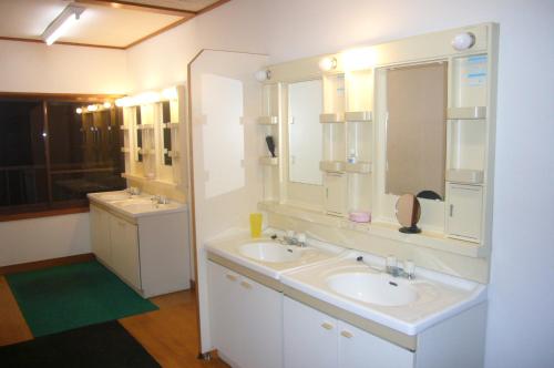 南鱼沼市双子旅馆的一间带两个盥洗盆和大镜子的浴室