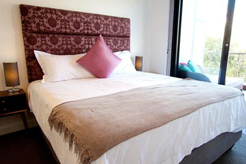 开普敦Rockwell 304的卧室配有一张带粉红色枕头的大床