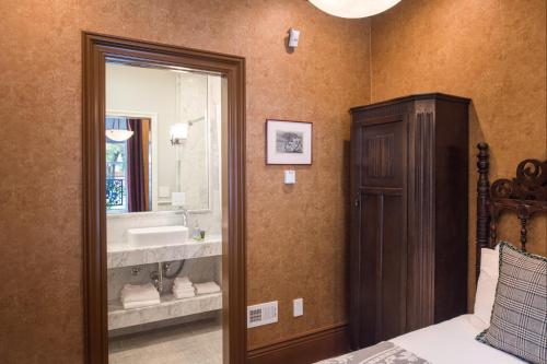 旧金山Monte Cristo Bed and Breakfast的浴室设有床、水槽和镜子