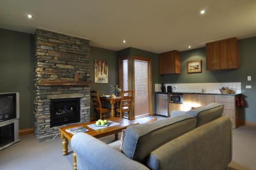 瓦纳卡Lansdown Peaks Apartments的客厅设有两张沙发和一个石头壁炉