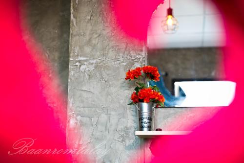 沙美岛班罗塔莱旅馆的放在架子上的花瓶,上面有红花