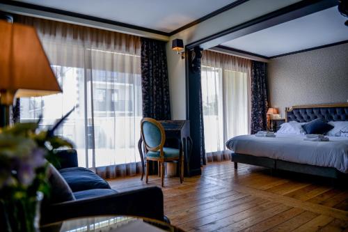 阿卡雄Hôtel Villa-Lamartine的配有一张床、一张书桌和一扇窗户的酒店客房