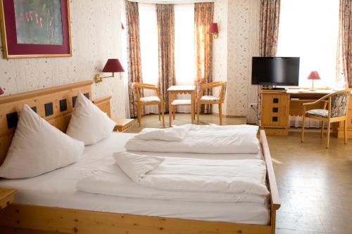罗滕伯格赫希酒店的一间卧室配有两张床、一张桌子和一张书桌