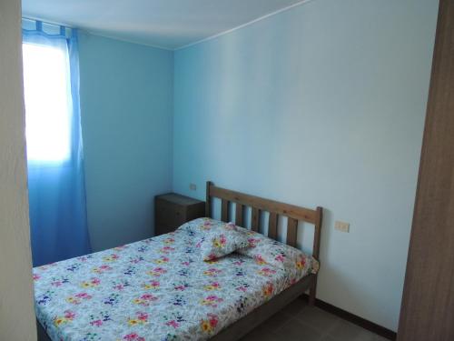 阿尔本加Appartamenti Camping Rivamare的一张小床,位于一个蓝色的墙壁内